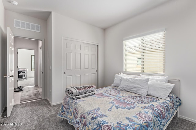 bedroom featuring a closet, visible vents, baseboards, and carpet