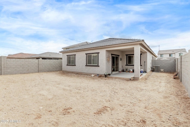 back of property featuring a patio area, central air condition unit, stucco siding, and a fenced backyard