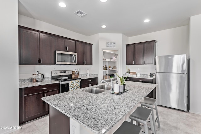 kitchen featuring dark brown cabinetry, visible vents, appliances with stainless steel finishes, and a sink