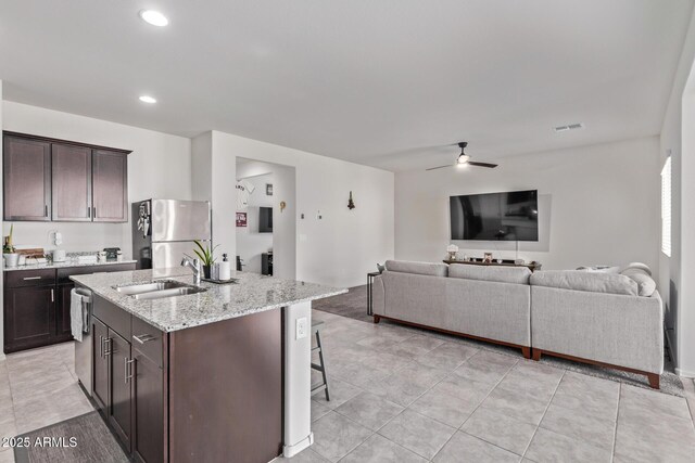 kitchen with dark brown cabinetry, visible vents, stainless steel appliances, and a sink