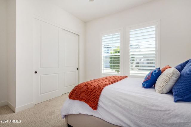 bedroom featuring light carpet and a closet