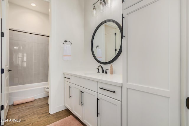 full bathroom featuring vanity, tiled shower / bath combo, wood-type flooring, and toilet