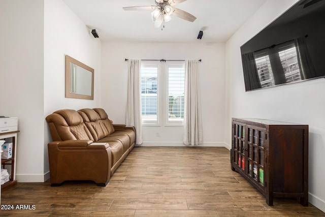 living area with ceiling fan and light hardwood / wood-style floors