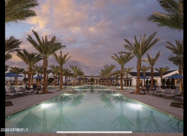 pool at dusk featuring a patio area