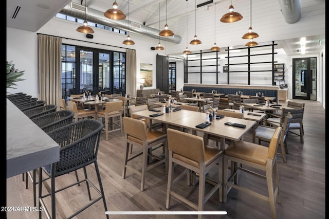 dining area featuring hardwood / wood-style floors, french doors, and a high ceiling