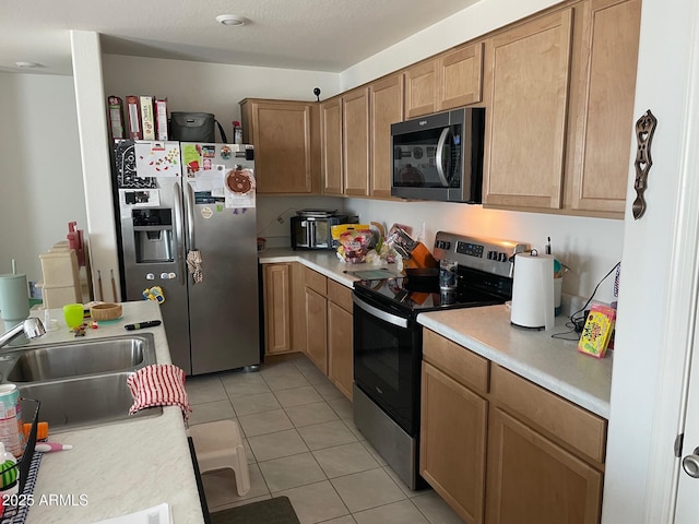 kitchen featuring sink, stainless steel appliances, and light tile patterned flooring