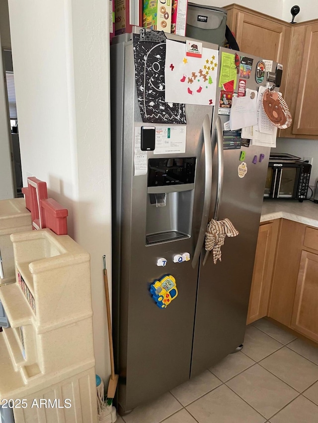 kitchen featuring light tile patterned floors and stainless steel fridge with ice dispenser