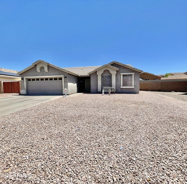 ranch-style home with stucco siding, fence, an attached garage, and concrete driveway