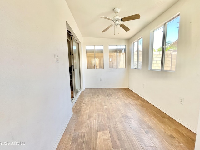 unfurnished room with ceiling fan, wood finished floors, and baseboards