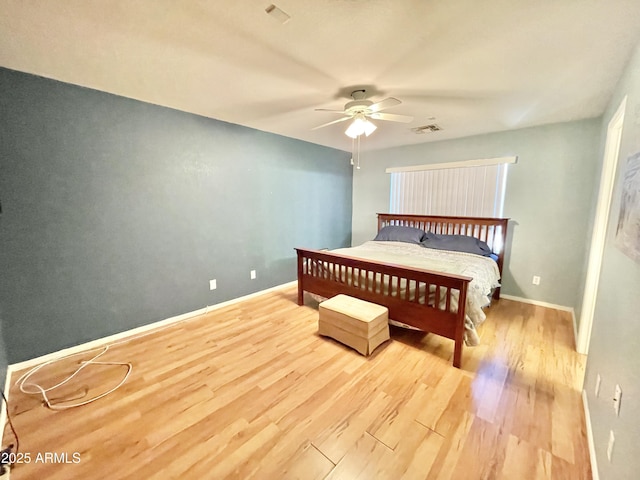 bedroom with wood finished floors, baseboards, and a ceiling fan