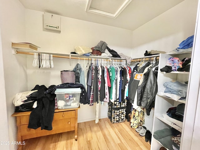 walk in closet featuring wood finished floors and attic access
