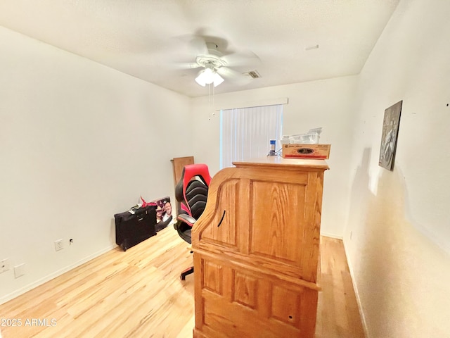 home office with a ceiling fan, light wood-style floors, and baseboards
