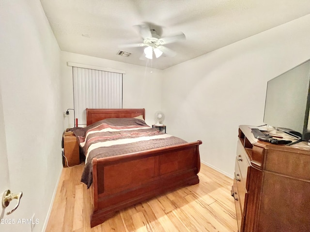 bedroom with light wood-style flooring, baseboards, and a ceiling fan