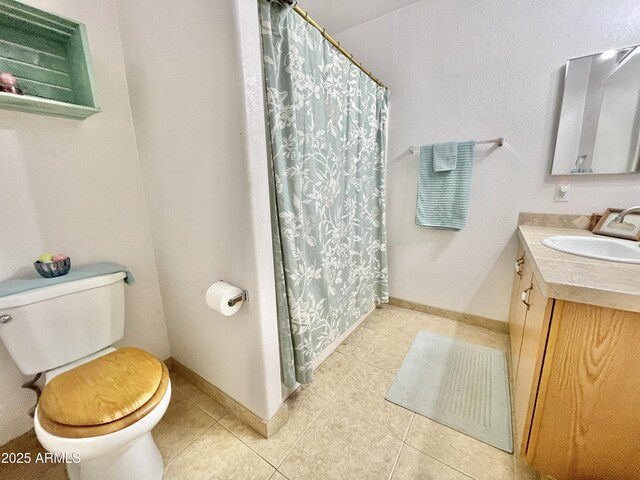 bathroom with toilet, tile patterned floors, vanity, a shower with curtain, and baseboards