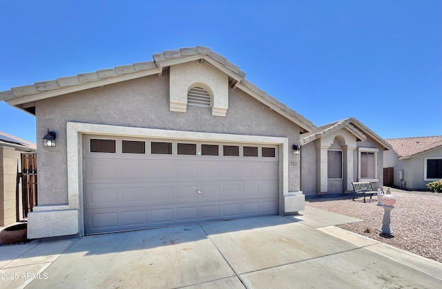 ranch-style house with concrete driveway, stucco siding, and an attached garage