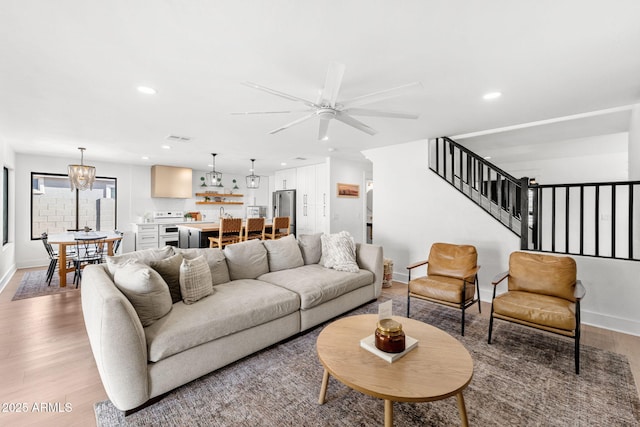 living room with ceiling fan and light hardwood / wood-style flooring