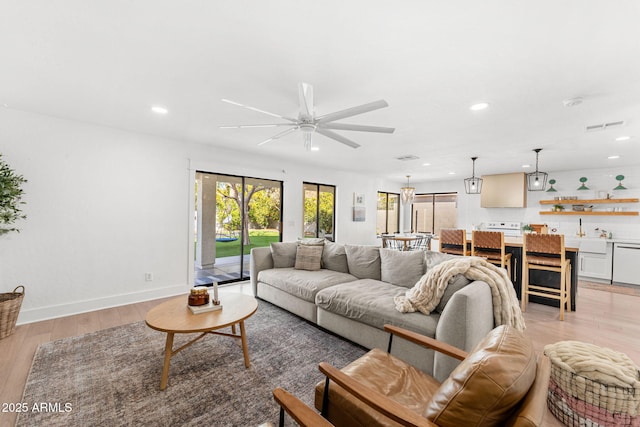 living room featuring ceiling fan and light wood-type flooring