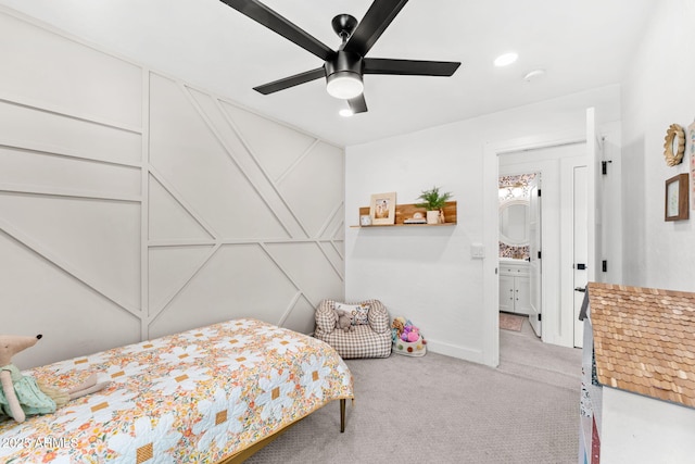 bedroom with ceiling fan, light carpet, and ensuite bath