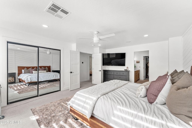 carpeted bedroom with a closet, ceiling fan, and ensuite bathroom