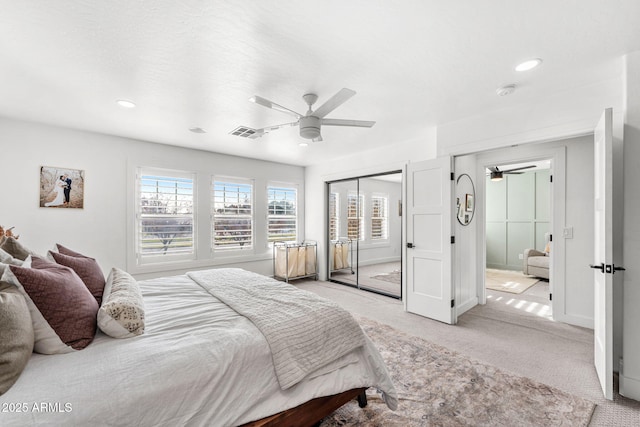 bedroom featuring light colored carpet, a closet, and ceiling fan