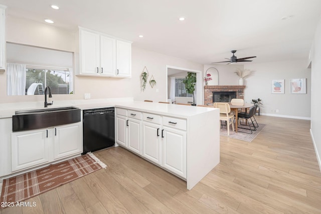 kitchen with white cabinetry, sink, kitchen peninsula, and black dishwasher