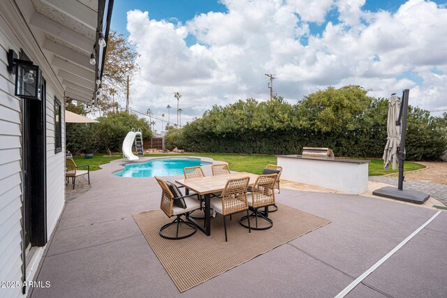 view of pool featuring a lawn, area for grilling, a patio, and a water slide