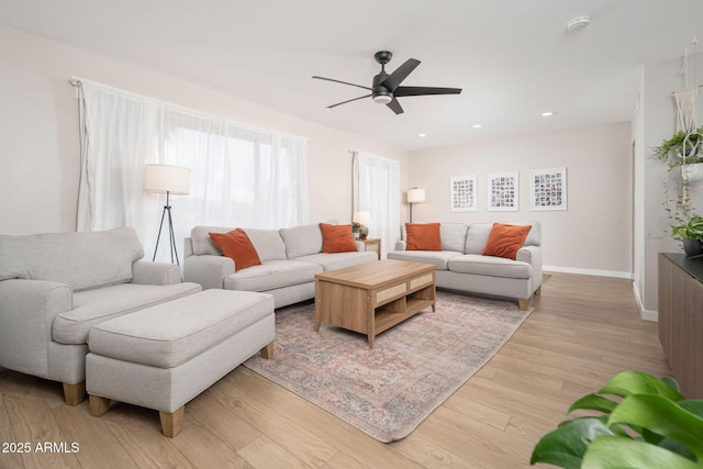 living room with light hardwood / wood-style floors and ceiling fan