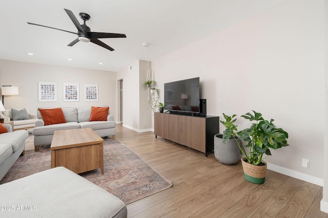 living room featuring light hardwood / wood-style flooring and ceiling fan