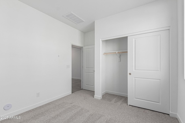 unfurnished bedroom featuring a closet and light carpet