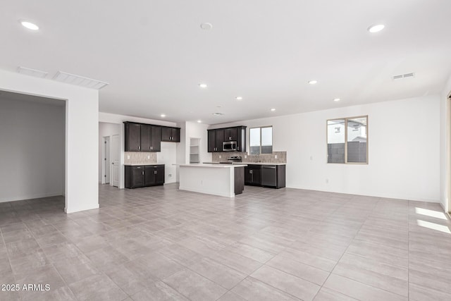 unfurnished living room with sink and light tile patterned flooring