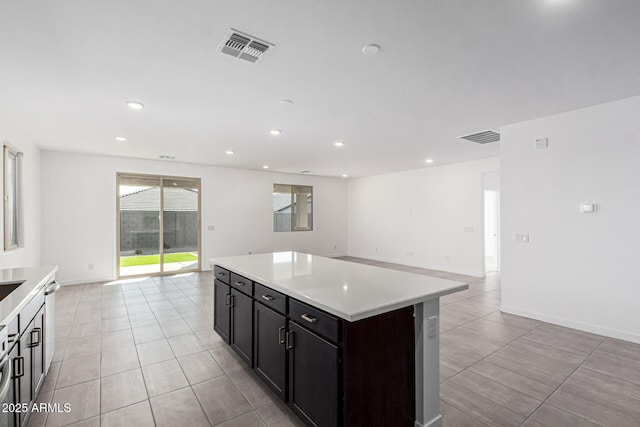 kitchen with light tile patterned flooring, dishwasher, and a kitchen island