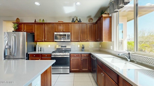 kitchen with light countertops, recessed lighting, light tile patterned floors, stainless steel appliances, and decorative backsplash