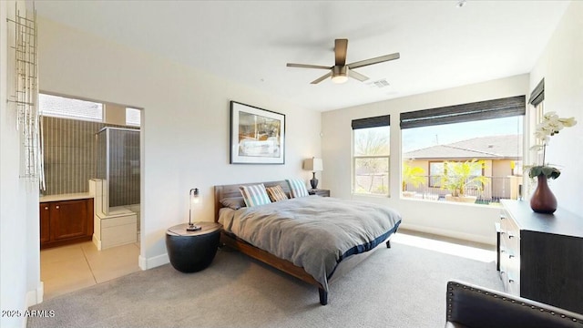 bedroom with light colored carpet, light tile patterned floors, baseboards, ensuite bath, and visible vents