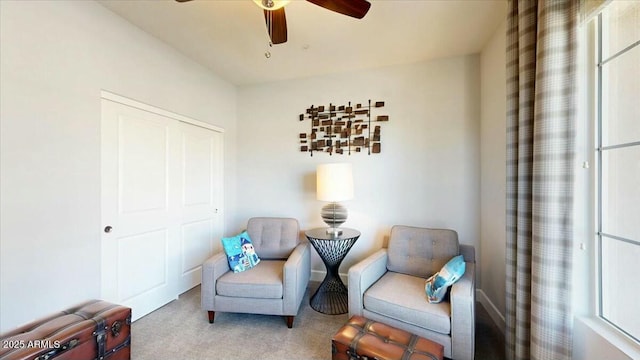 living area with carpet floors and a ceiling fan
