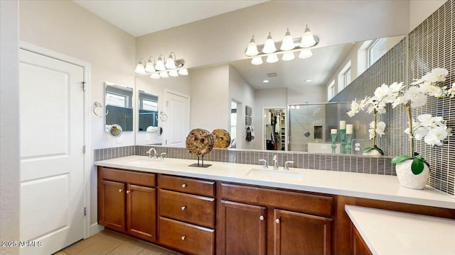 full bathroom with double vanity, a sink, tile patterned flooring, and a shower stall