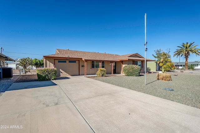 ranch-style home featuring a garage and central air condition unit