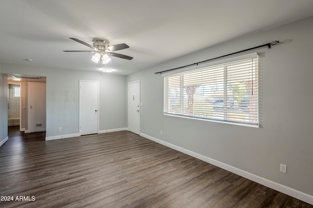 empty room with ceiling fan and dark hardwood / wood-style flooring