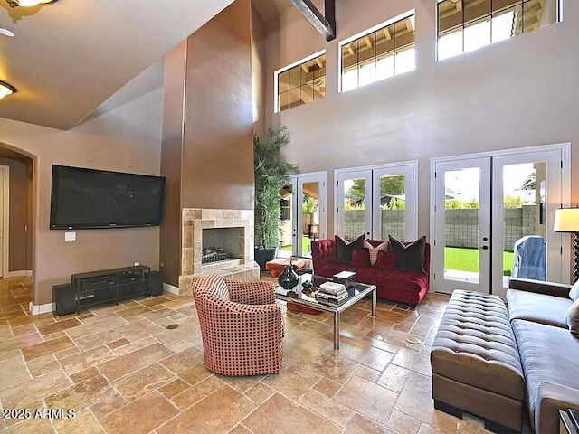 3804 E Camelback Rd, Phoenix, AZ 85018 - living area with stone tile floors, high vaulted ceiling, french doors, and a fireplace