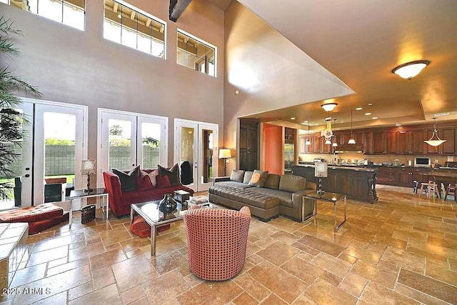 3804 E Camelback Rd, Phoenix, AZ 85018 - living room featuring stone tile flooring, a towering ceiling, healthy amount of natural light, and a raised ceiling