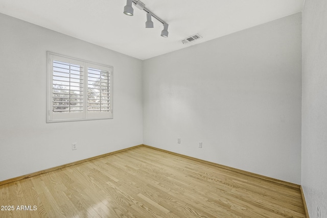 4530 E Desert Wind Dr, Phoenix, AZ 85044 - empty room featuring rail lighting, wood finished floors, and baseboards