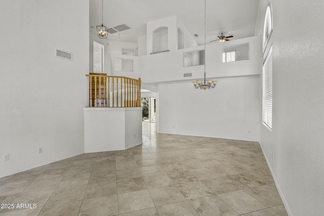 4530 E Desert Wind Dr, Phoenix, AZ 85044 - unfurnished living room featuring a towering ceiling, a chandelier, ceiling fan, and baseboards