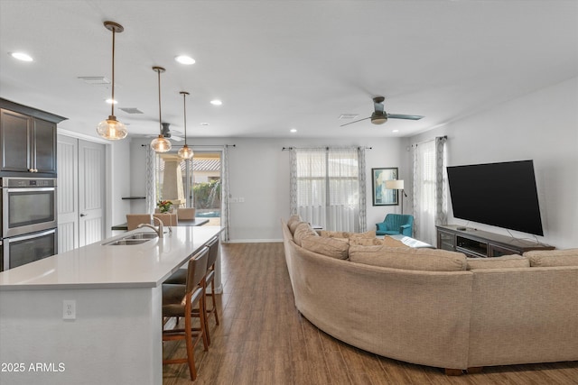 living room with ceiling fan, dark hardwood / wood-style flooring, and sink