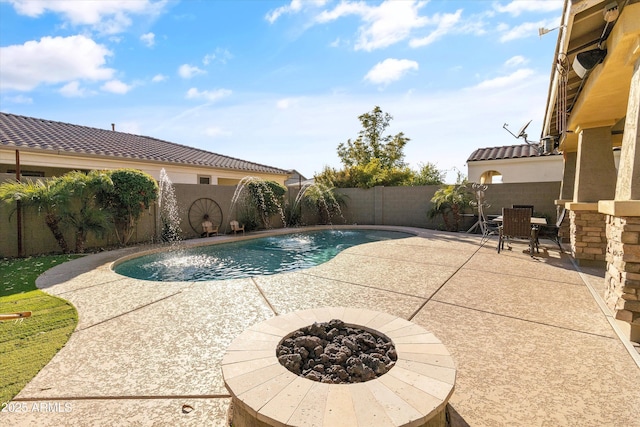 view of swimming pool featuring a patio area, pool water feature, and an outdoor fire pit