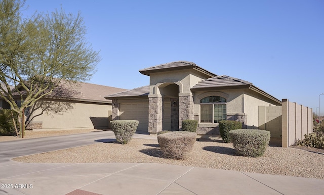2930 W La Salle St, Phoenix, AZ 85041 - view of front facade with a tile roof, stone siding, concrete driveway, stucco siding, and an attached garage