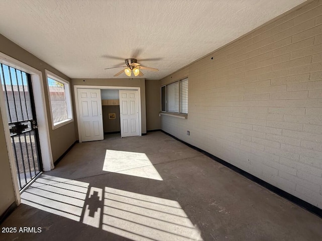 unfurnished sunroom featuring ceiling fan