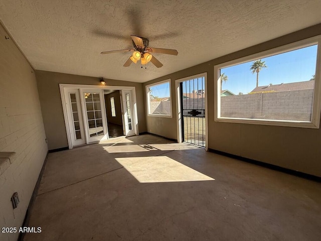 unfurnished sunroom with ceiling fan