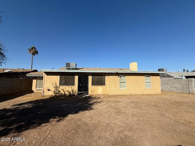 back of house with central AC unit