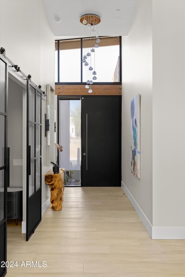 foyer entrance featuring a barn door, light wood-type flooring, and floor to ceiling windows