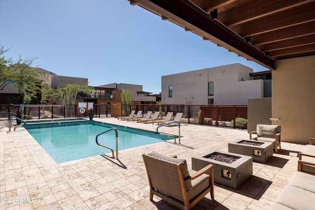 view of pool featuring an outdoor fire pit and a patio