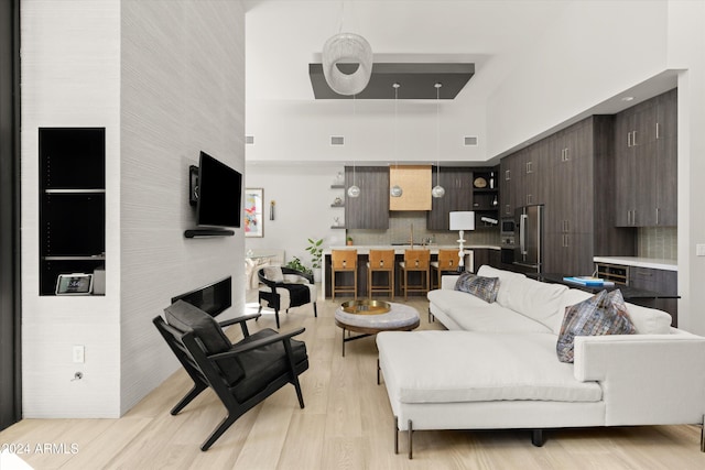 living room featuring a high ceiling and light wood-type flooring